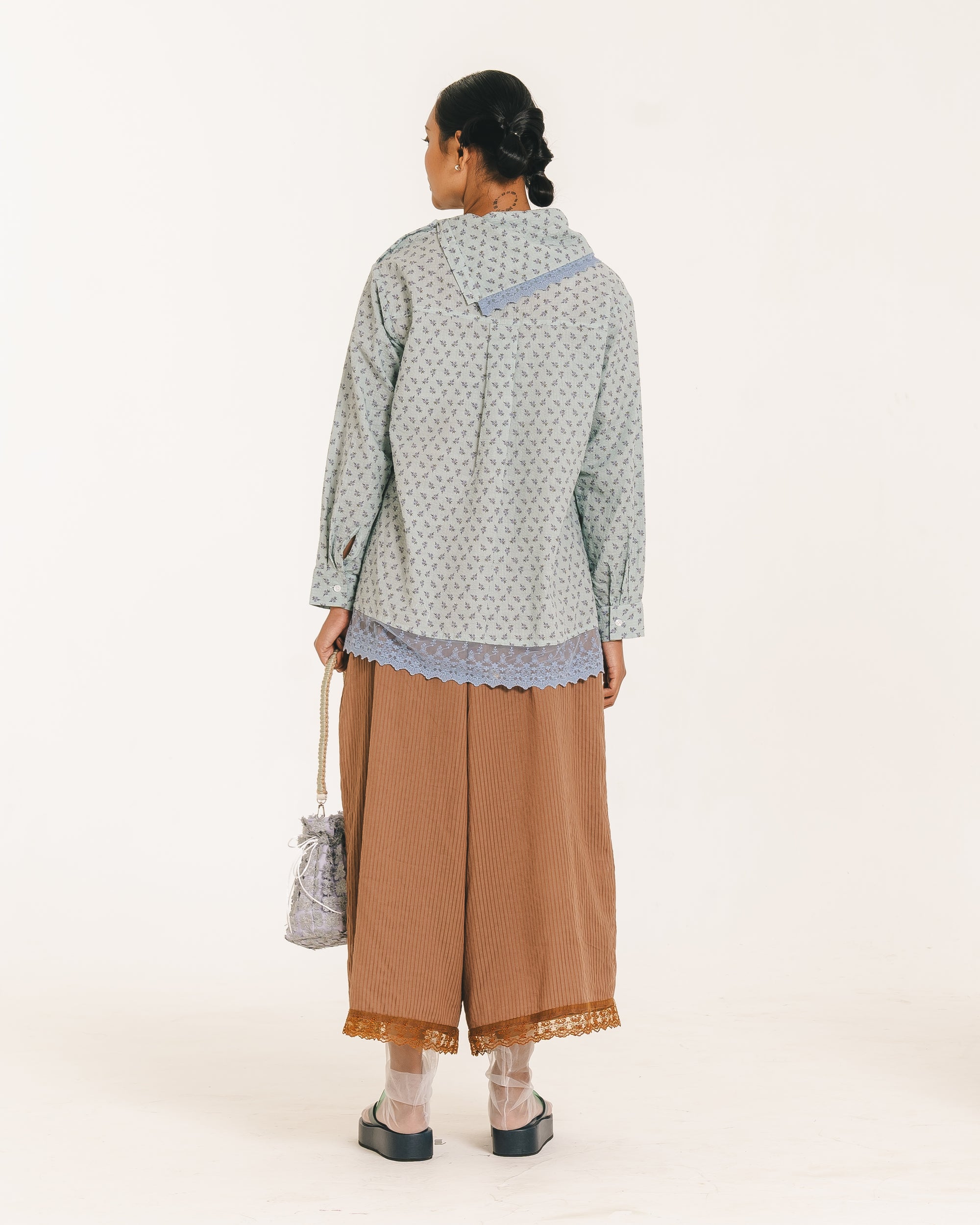 Image of Alice Longsleeve Blouse, a longsleeve blouse with a delicate floral print, featuring an asymmetrical neckline with a folded collar and lace trim accent.
