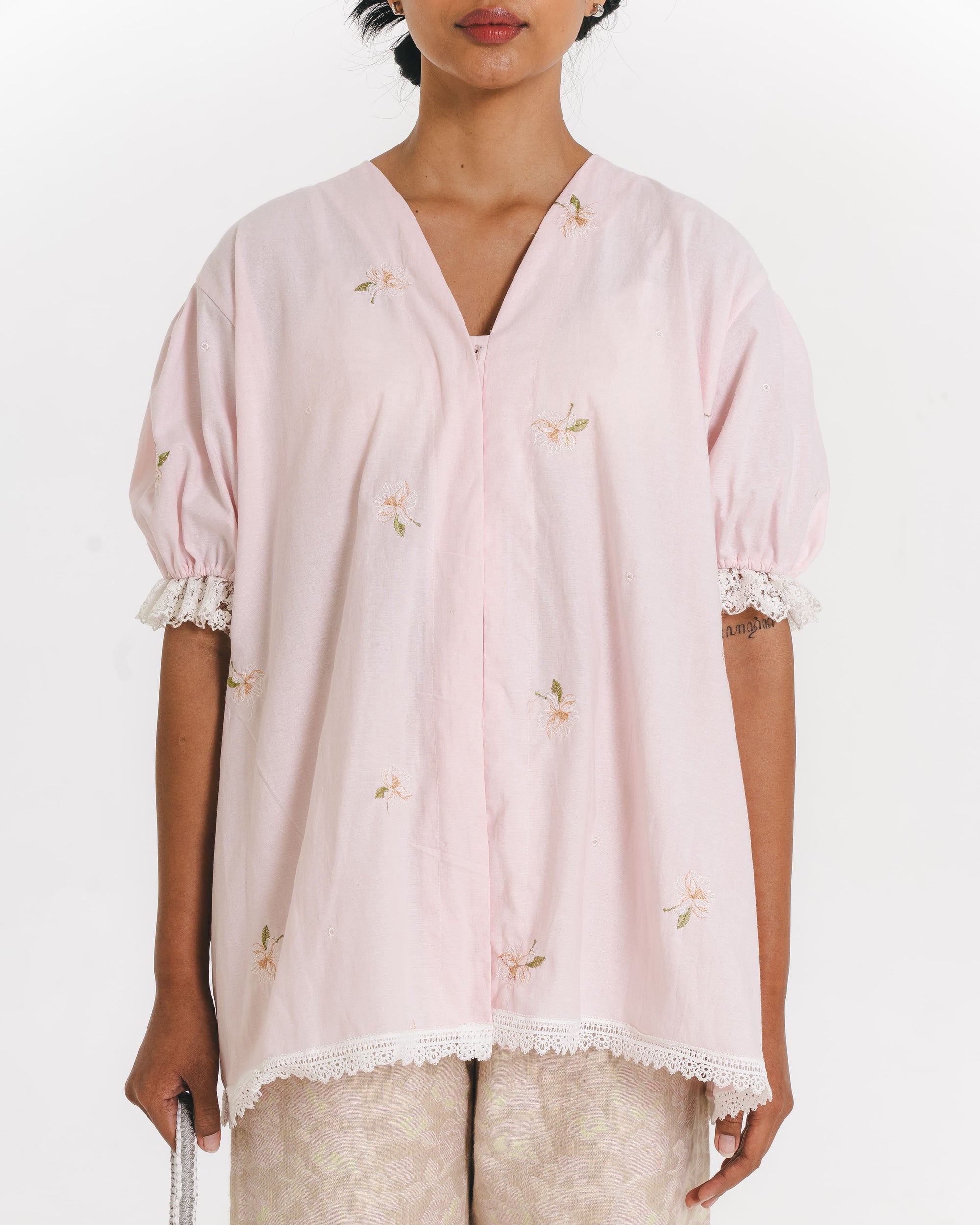Image of Nadine Blouse Pink, blouse with v-neckline and puffy sleeves, made from cotton with lace trim details.