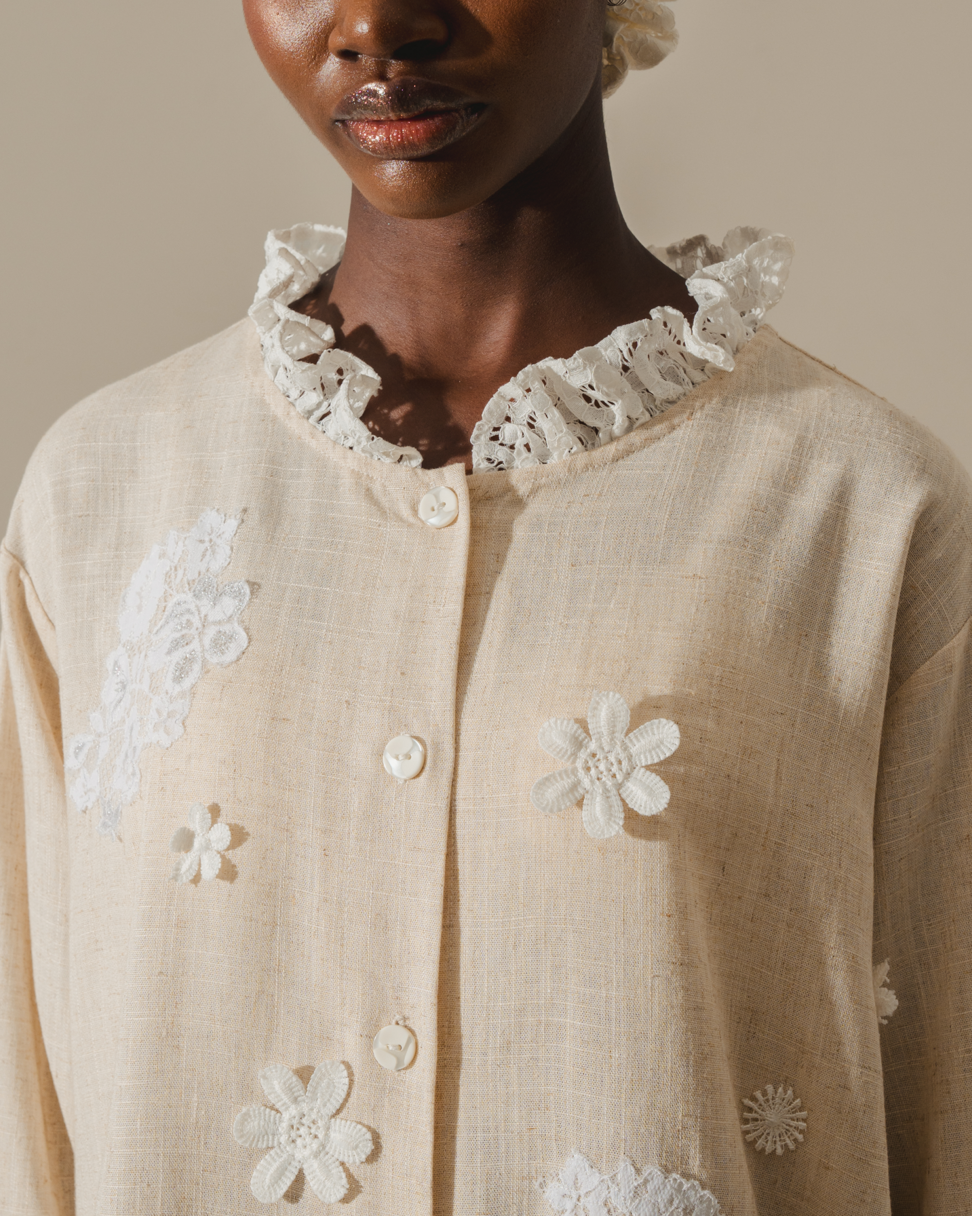 Image of Alette Embroidery Blouse, a longsleeve blouse made from deadstock linen, adorned with delicate lace detailing on the hem and neckline.