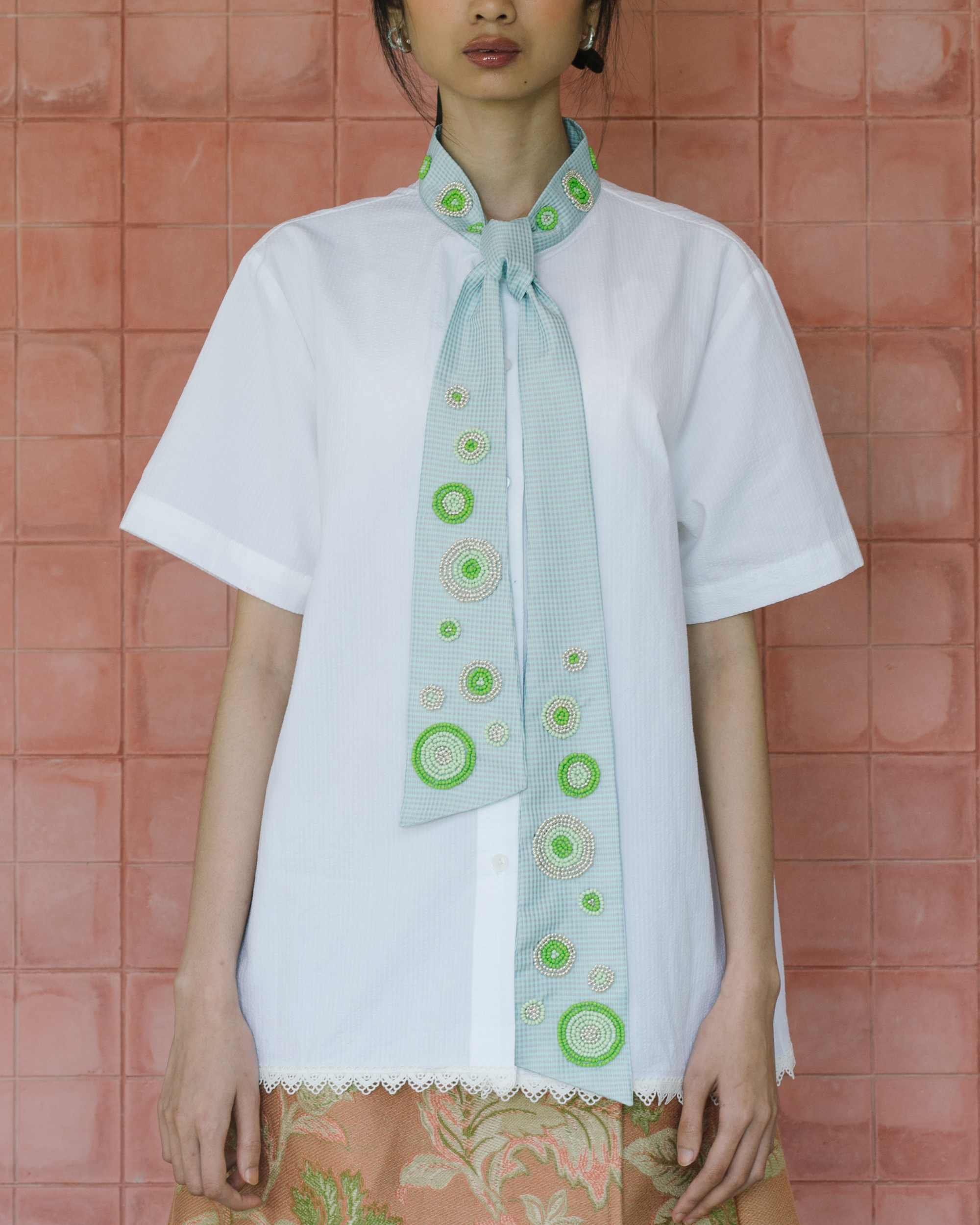 Image of Cath Beaded Shirt Green, a relaxed shirt with a distinctive light blue tie and green beaded details.