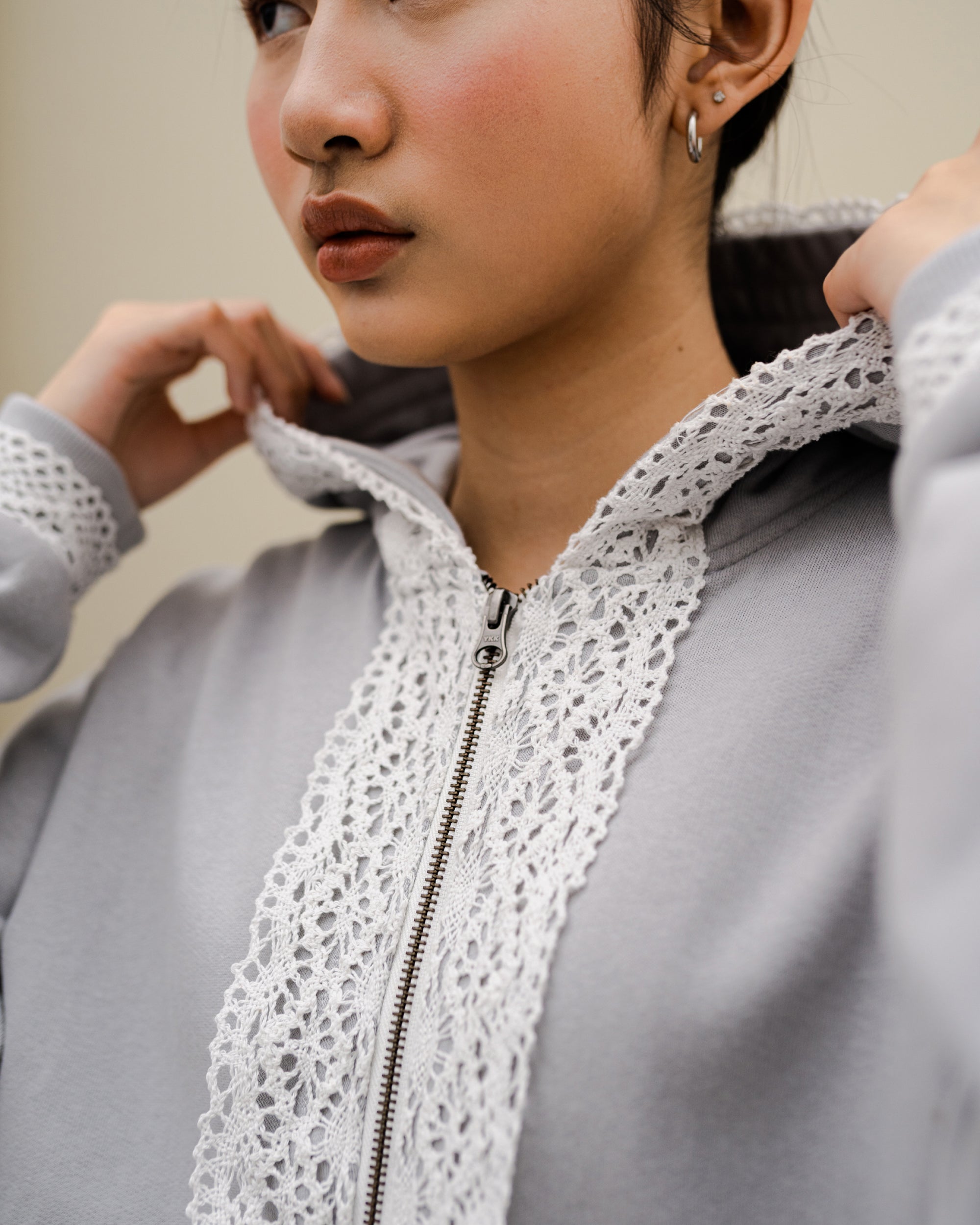 Image of Dune Lace Hoodie Grey, a hoodie jacket with lace detail on along the zipper.