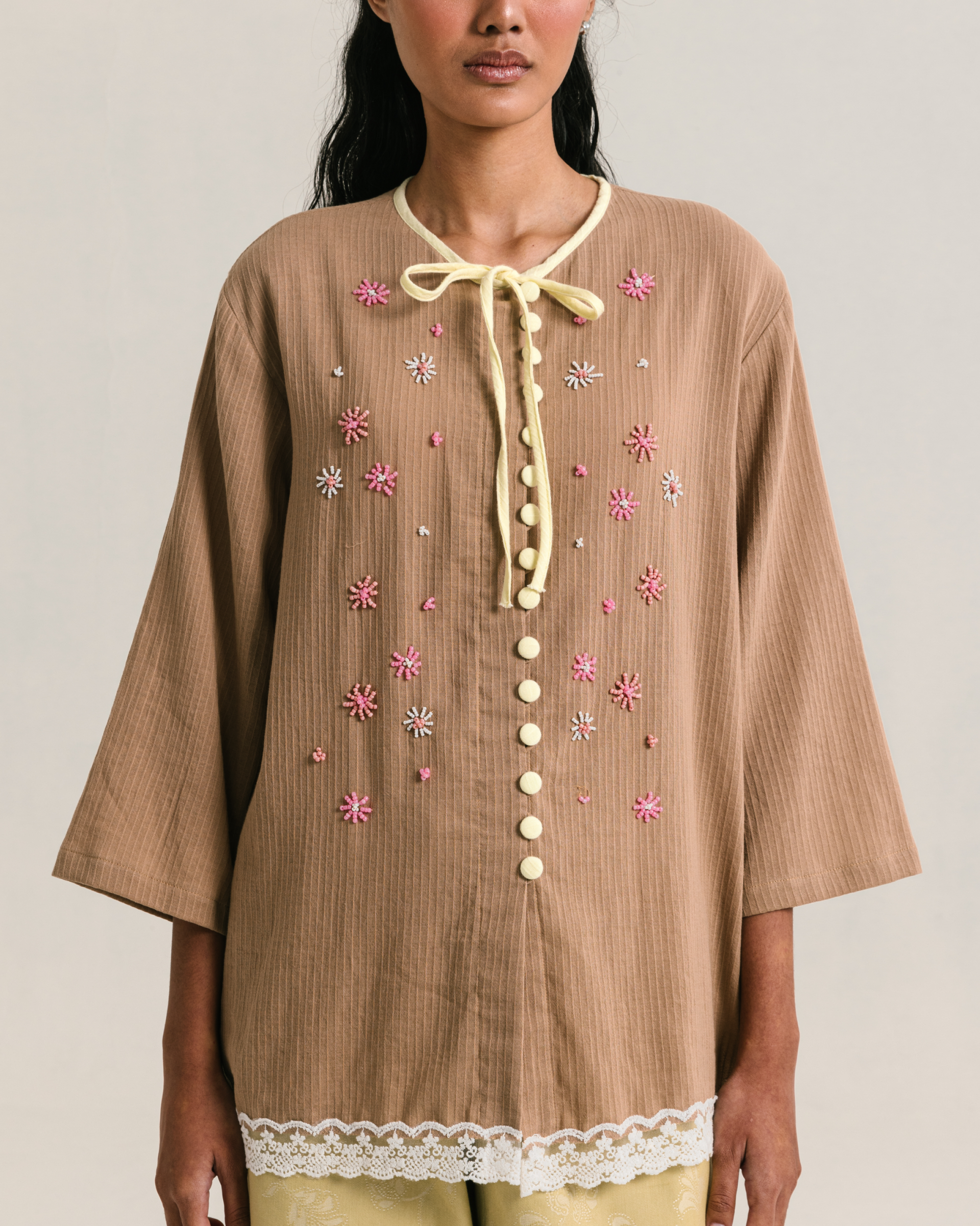 Image of Fleur Longsleeve Brown, a modest blouse made from cotton-poly, adorned with a hand-beaded flower on the front.