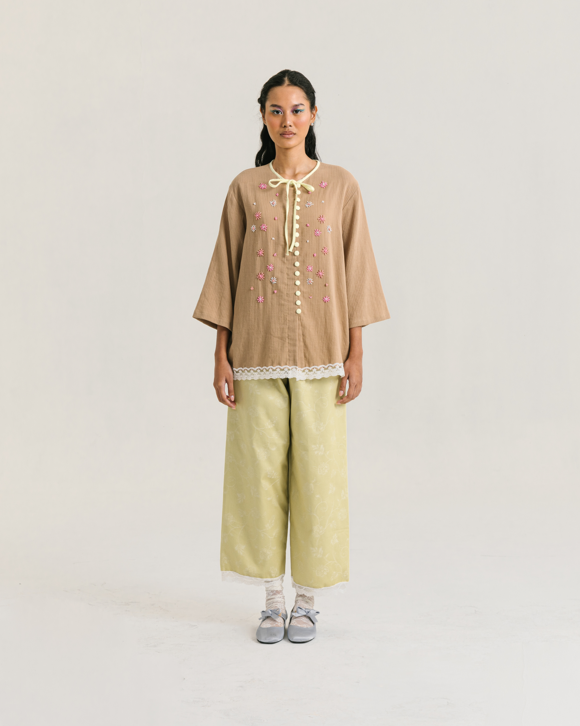 Image of Fleur Longsleeve Brown, a modest blouse made from cotton-poly, adorned with a hand-beaded flower on the front.