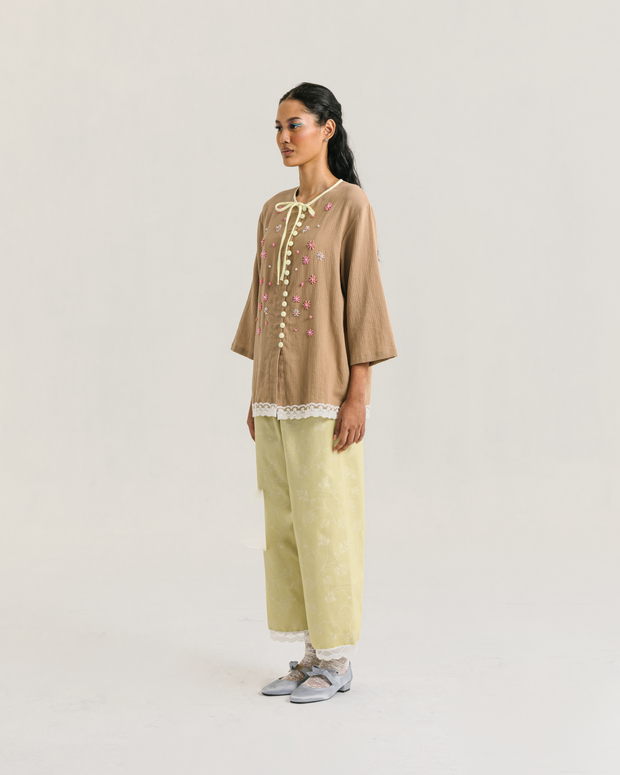 Image of Fleur Longsleeve Brown, a modest blouse made from cotton-poly, adorned with a hand-beaded flower on the front.