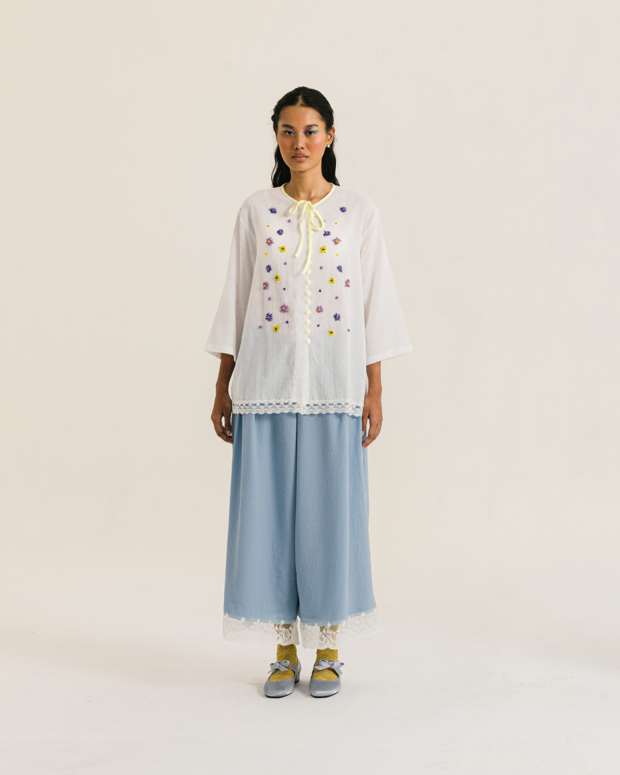 Image of Fleur Longsleeve White, a modest blouse made from cotton-poly, adorned with a hand-beaded flower on the front.