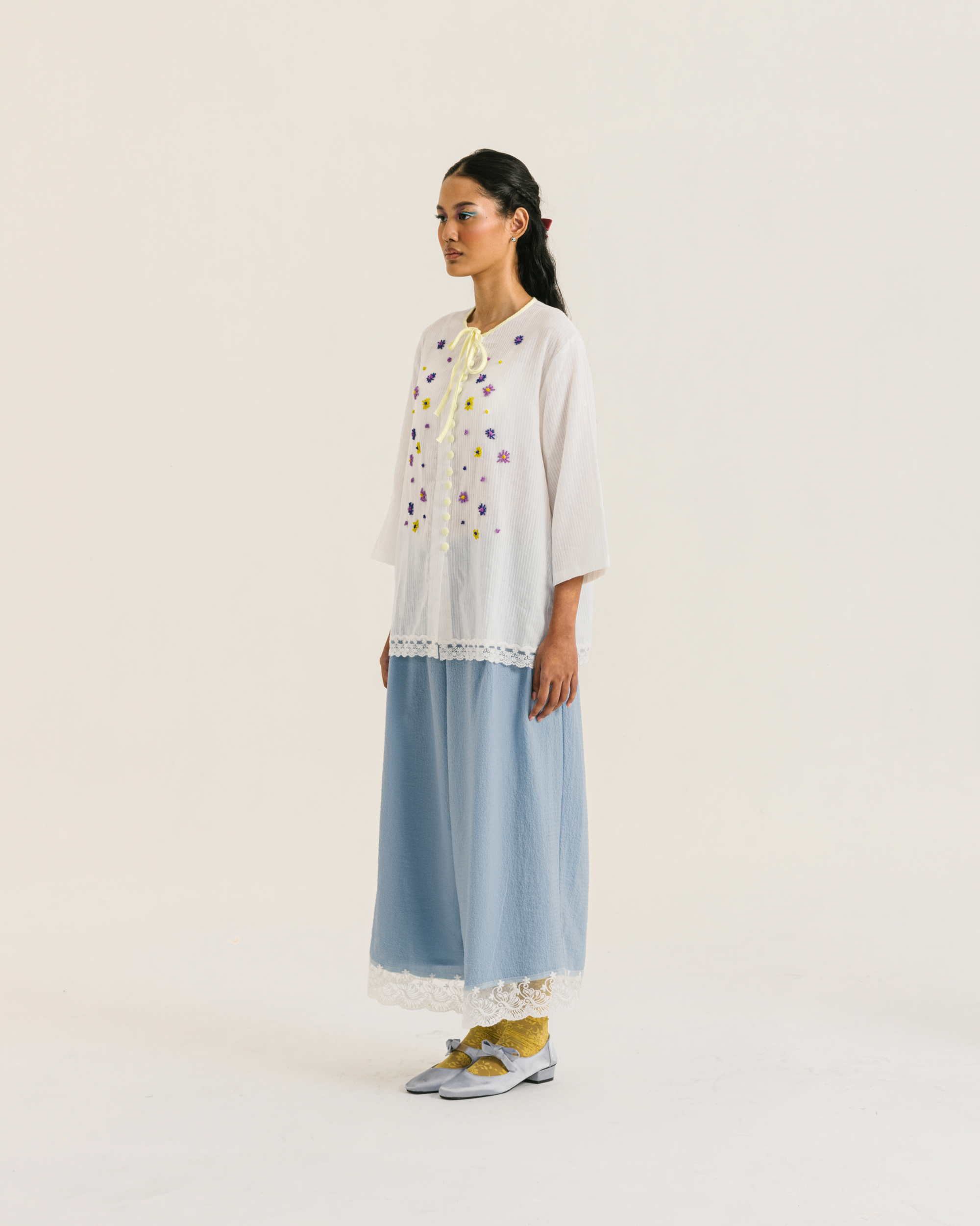 Image of Fleur Longsleeve White, a modest blouse made from cotton-poly, adorned with a hand-beaded flower on the front.