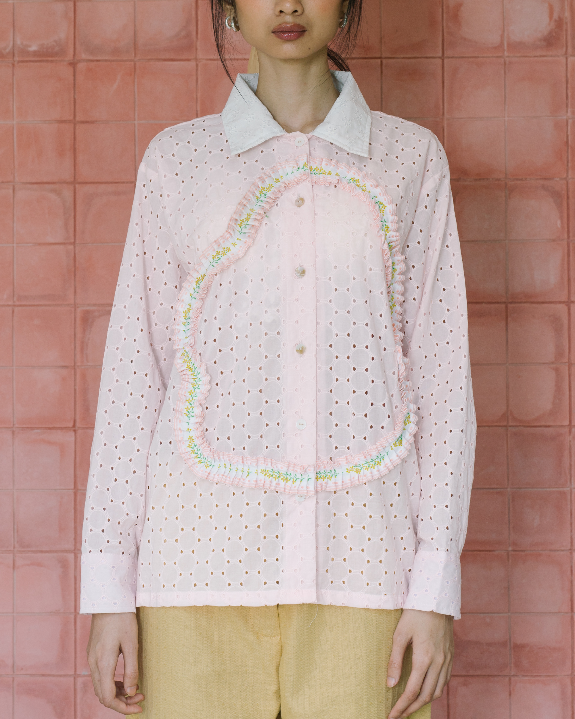 Image of Liesl Lace Longsleeve Shirt Pink, a classic long-sleeve shirt made from embroided cotton with ruffled trim as decorative shape on the front.