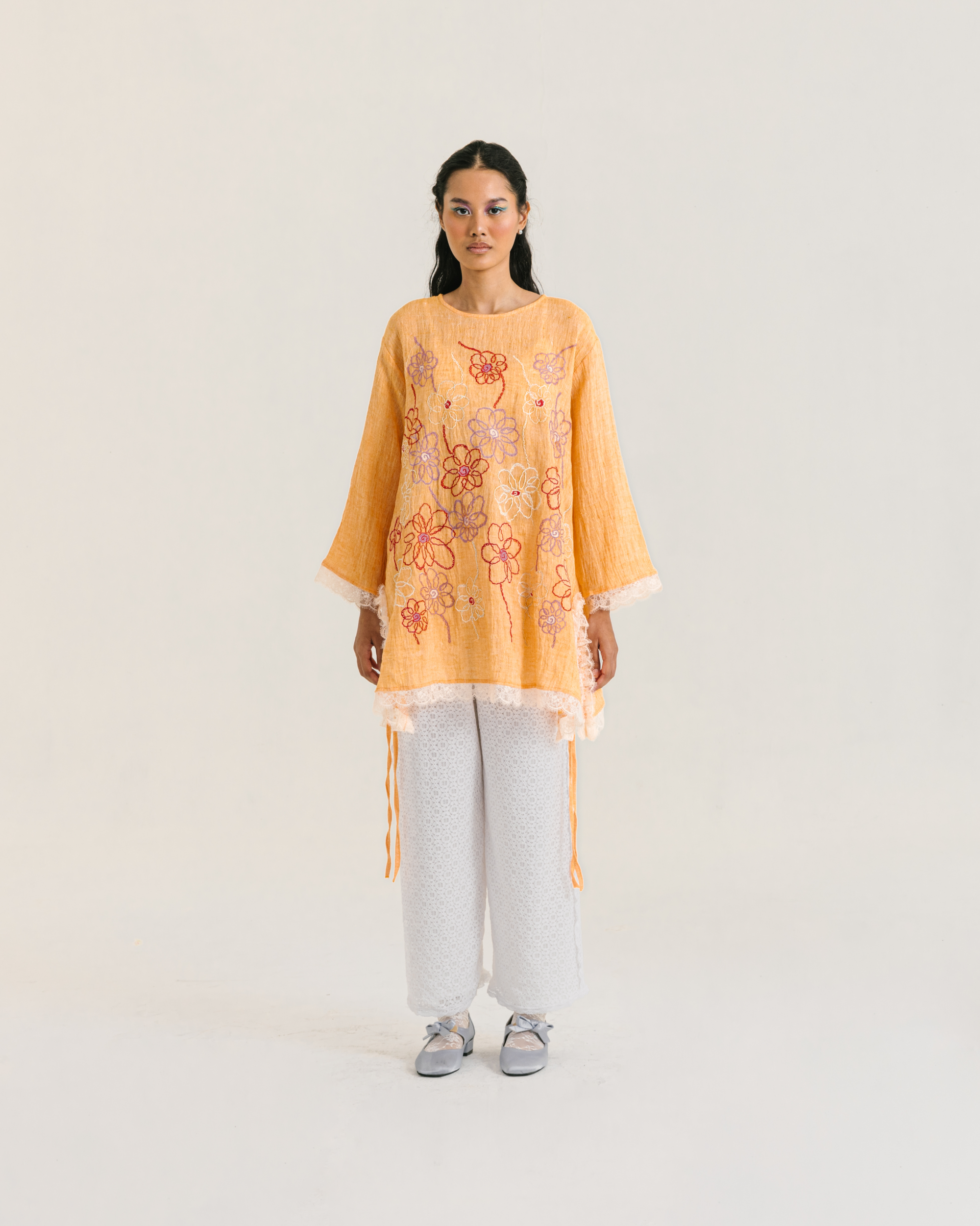 Image of Nora Embroidery Longsleeve Orange, a loose-fitting tunic made from cotton crepe, embroidered with chic floral design and adorned with delicate lace trims.