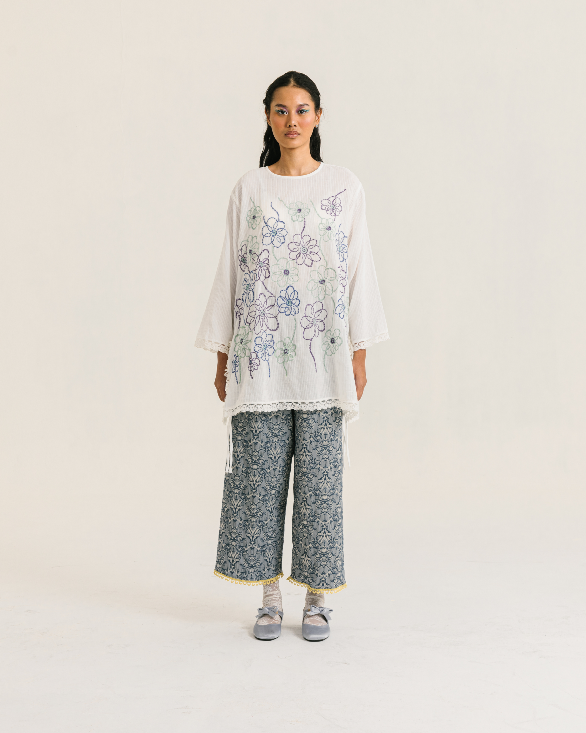 Image of Nora Embroidery Longsleeve White, a loose-fitting tunic made from cotton crepe, embroidered with chic floral design and adorned with delicate lace trims.