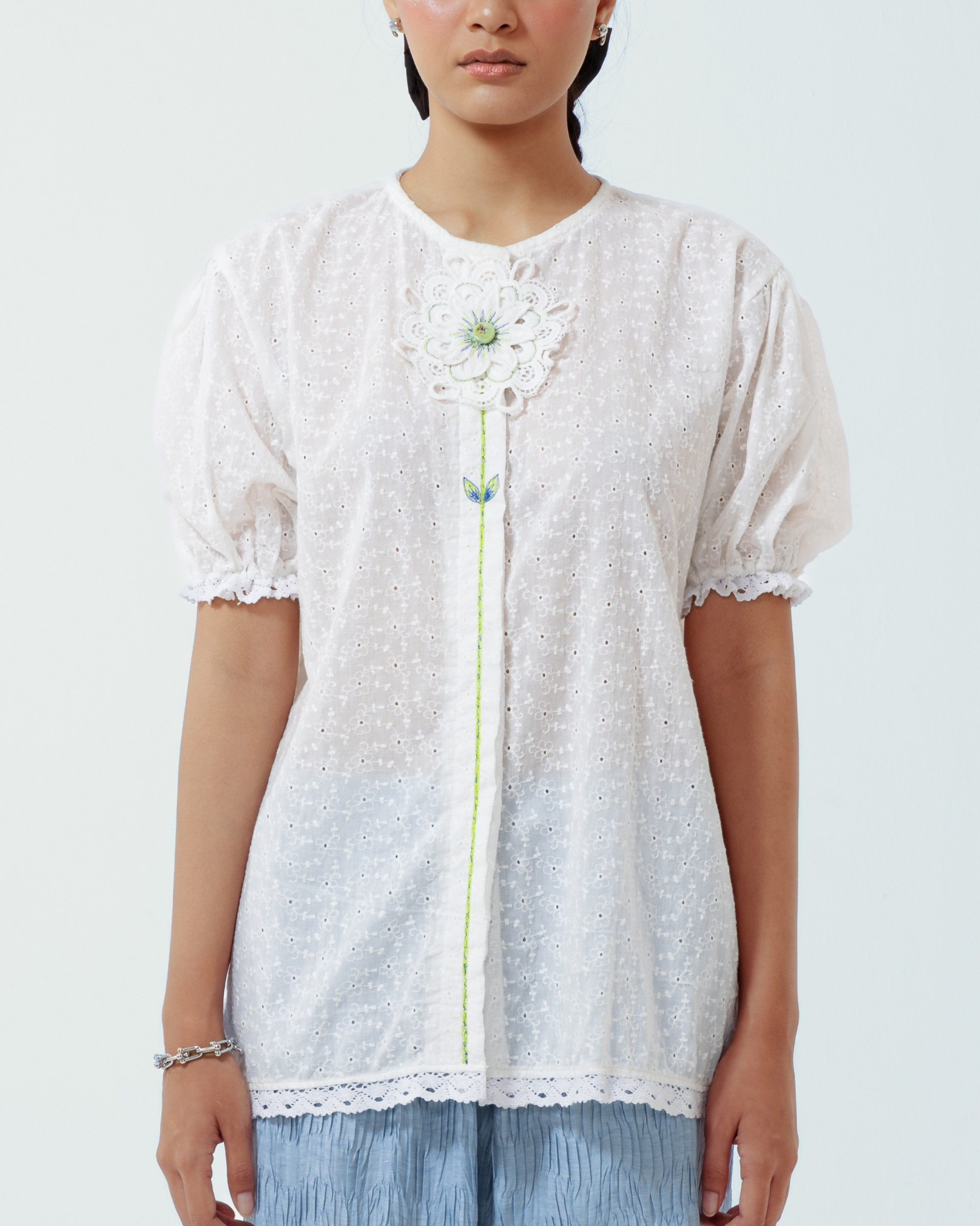 Image of Paloma Top, a blouse made from embroidered cotton with a puffy sleeves and hand-made floral patch on the front.