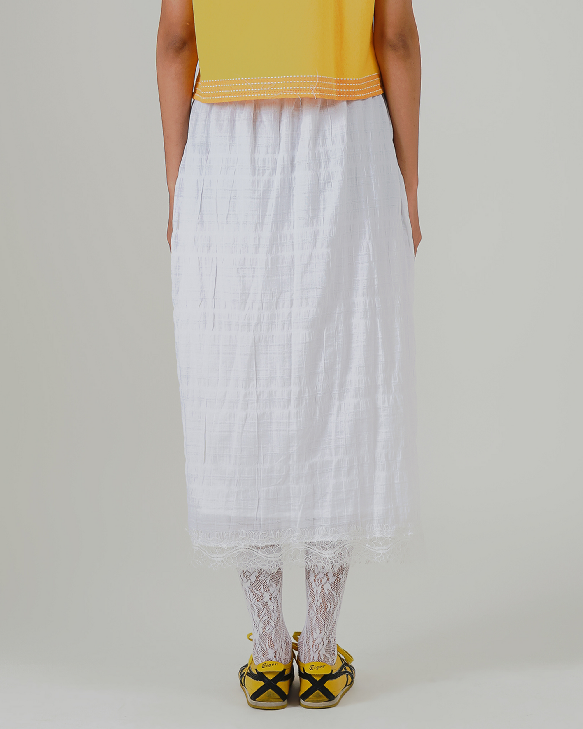 Image of Sasmita Embroidery Skirt, a midi skirt, adorned with flower embroidery and lace detailing at the hem.