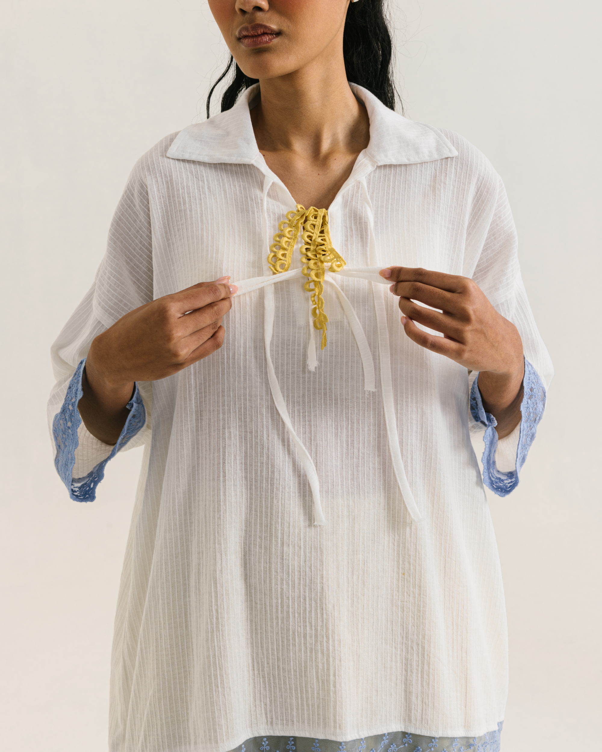 Image of Thea Longsleeve White, a blouse made from cotton with ribbon-like lace on the front.