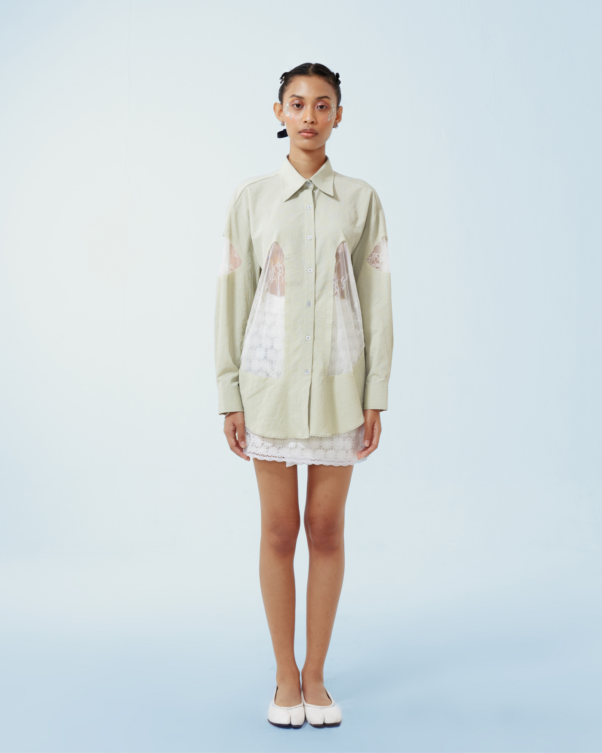 Image of Yoko Shirt Green, a longsleeve shirt made from cotton crepe, features a contrast lace cut-out details along both sides and the sleeves.